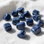 Sodalite tumblestones on linen background - small and large