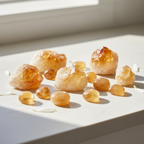 Citrine raw and tumblestone crystals on light background